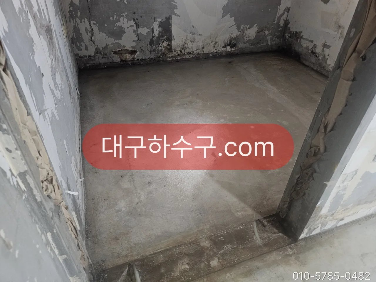 타일을 걷어낸 욕실 바닥의 미장 상태 — 방수 시공 전에 배관 연결부와 구배를 보는 바탕