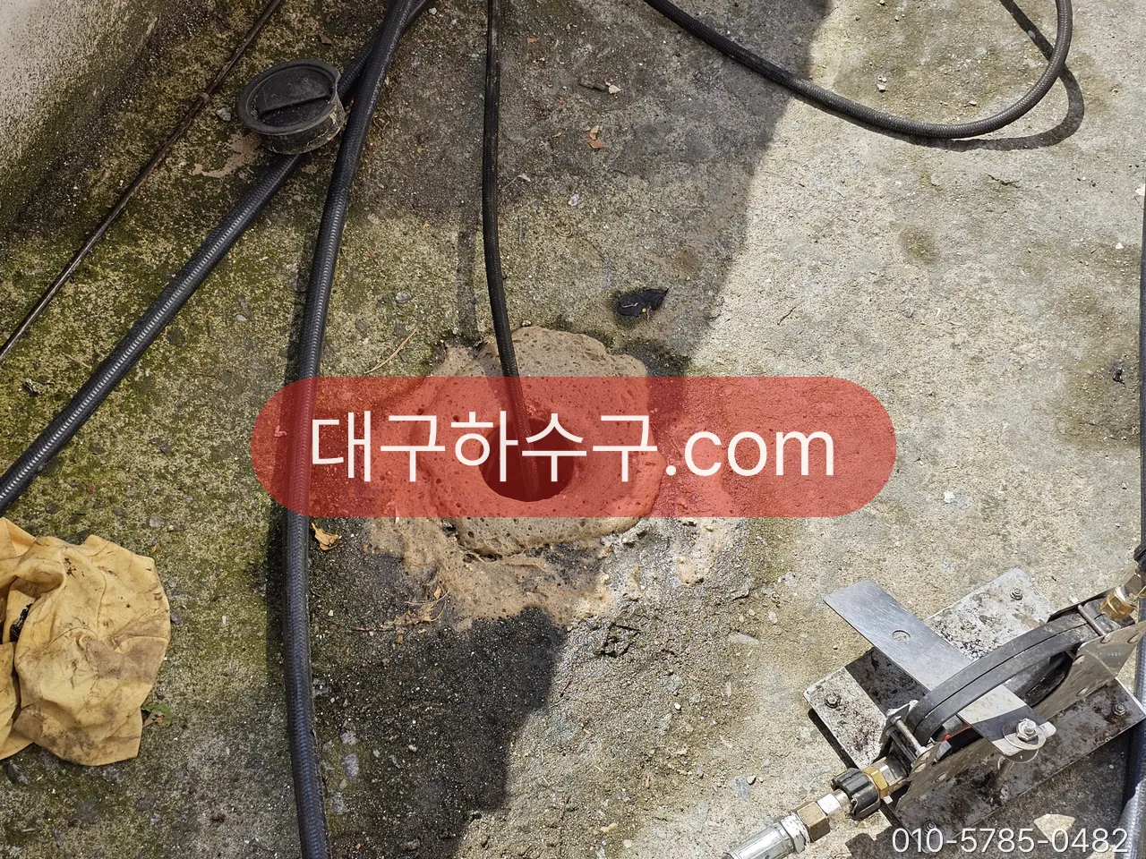 옥외 바닥 배수구에 스프링을 넣는 작업